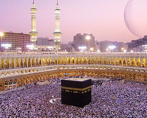 The Kaaba in Mecca Surrounded by Pilgrims at Sunset with Minarets and City Skyline HD wallpaper