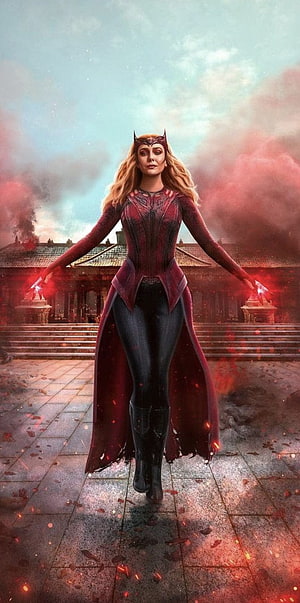 Scarlet Witch in red costume with glowing magic hands standing before a burning temple courtyard HD phone wallpaper