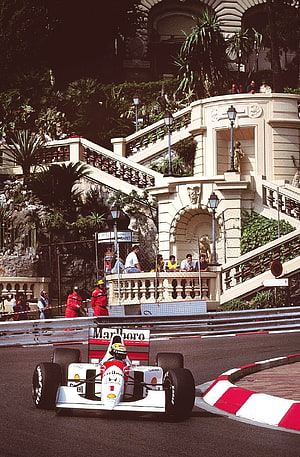 Ayrton Senna in a Ferrari Formula 1 car navigating the Monaco Grand Prix street circuit HD phone wallpaper
