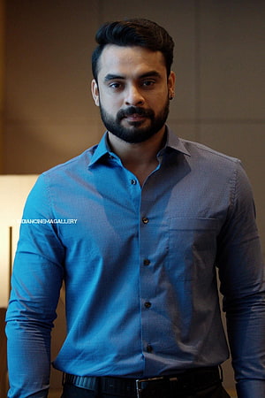Tovino Thomas in a blue button-down shirt with a full beard and styled hair HD phone wallpaper
