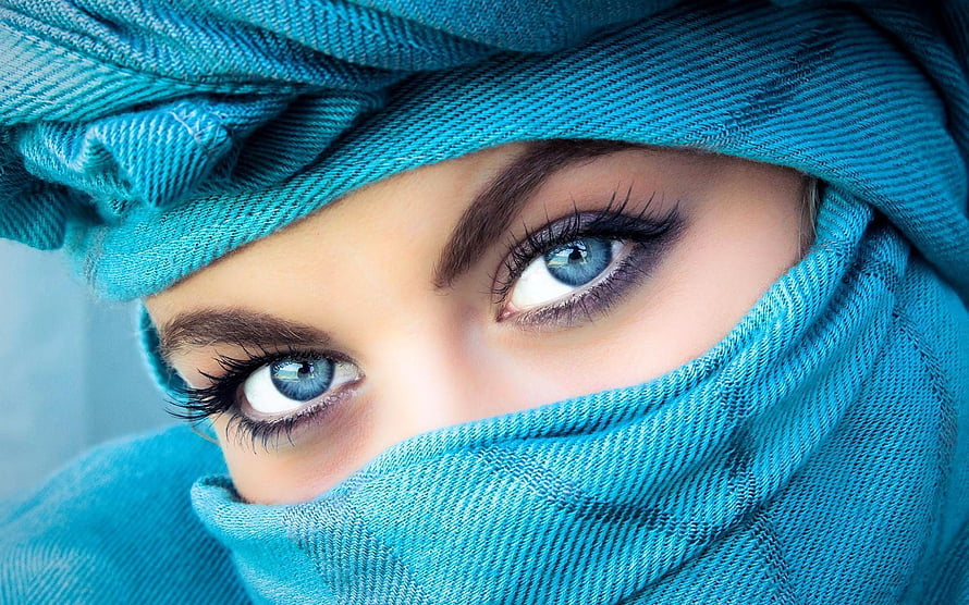 Close-up portrait of a woman with striking blue eyes wearing a teal hijab HD wallpaper