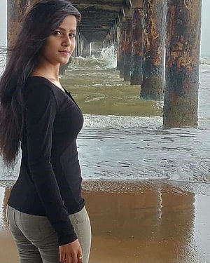 Vaishnavi Chaitanya Standing Under a Rusty Pier on a Sandy Beach HD phone wallpaper
