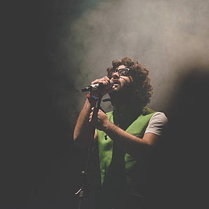 Arijit Singh performing live on stage with dramatic smoke and lighting HD phone wallpaper