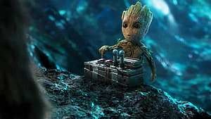 Baby Groot Operating a Sci-Fi Control Panel in a Dark Cavern HD wallpaper