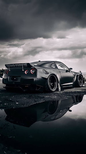 Matte Black Nissan R35 GT-R Widebody Stance with Water Reflection Under Stormy Sky HD phone wallpaper