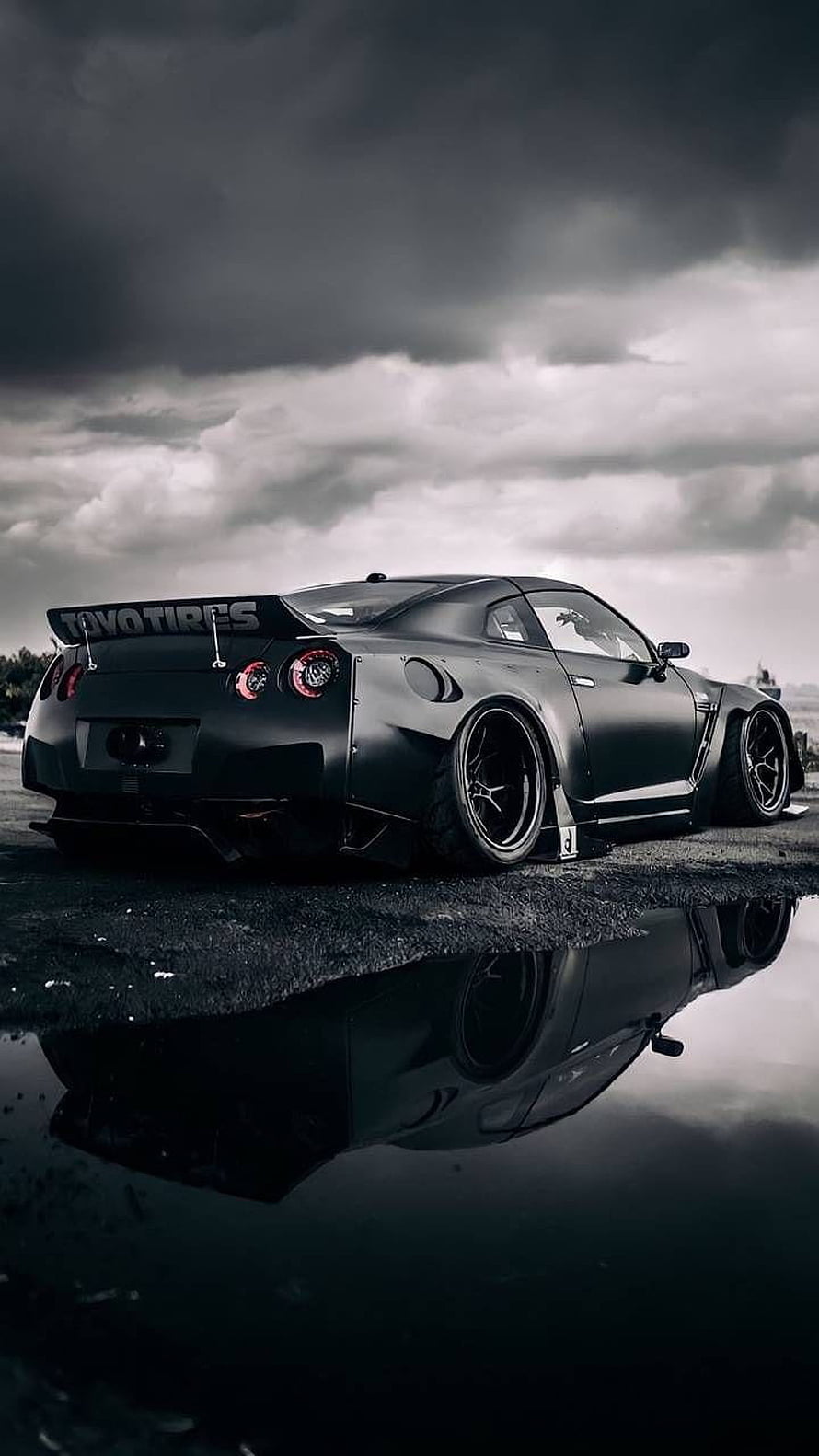 Matte Black Nissan R35 GT-R Widebody Stance with Water Reflection Under Stormy Sky HD phone wallpaper