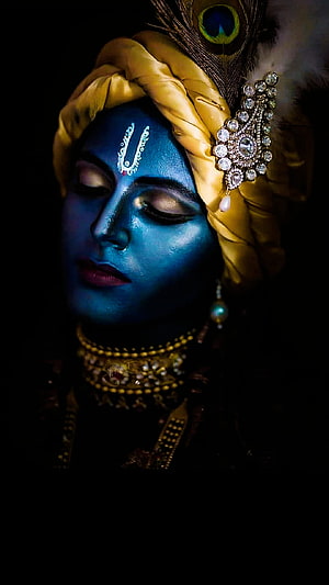Krishna Portrait with Blue Face Paint, Golden Turban, Peacock Feather, and Ornate Jewelry HD phone wallpaper