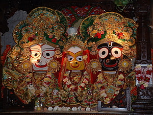 Ornate Jagannath Temple Deities with Elaborate Gold and Floral Decorations HD wallpaper