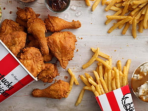 KFC Fried Chicken and French Fries with Dipping Sauces on Rustic Wooden Table HD wallpaper