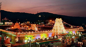Tirumala Temple Complex Illuminated at Dusk with Vibrant Gopuram and Hillside View HD wallpaper