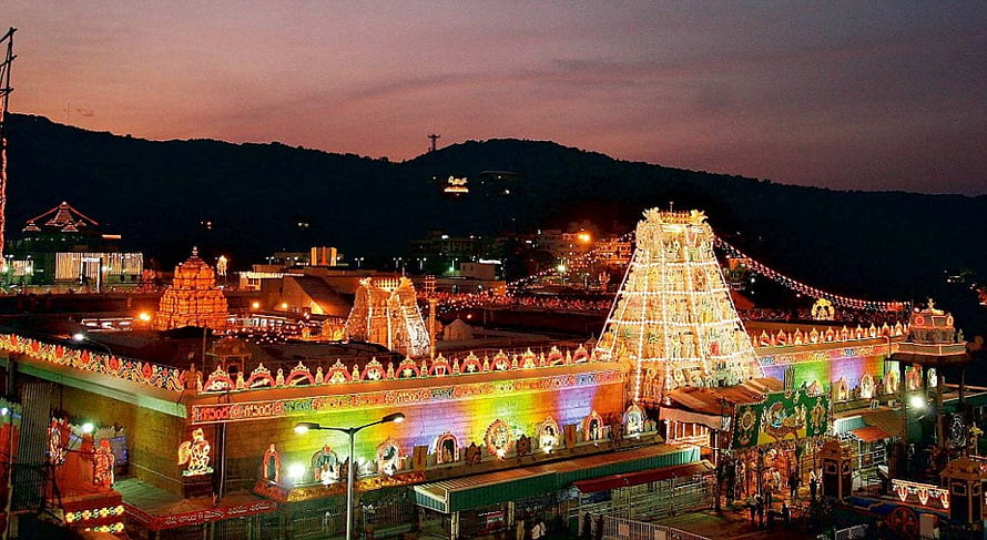 Tirumala Temple Complex Illuminated at Dusk with Vibrant Gopuram and Hillside View HD wallpaper