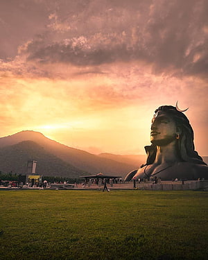 Adiyogi Shiva Statue at Sunrise with Mountain Silhouette and Golden Sky HD phone wallpaper