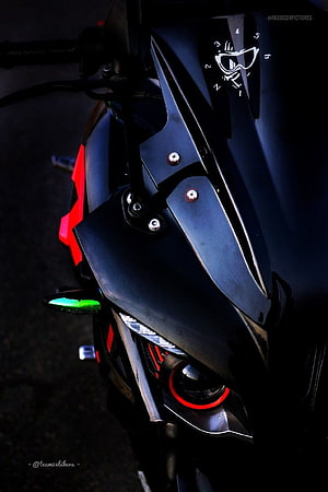 Close-up of a modified RS 200 motorcycle front fairing with red accents and dark matte finish HD phone wallpaper