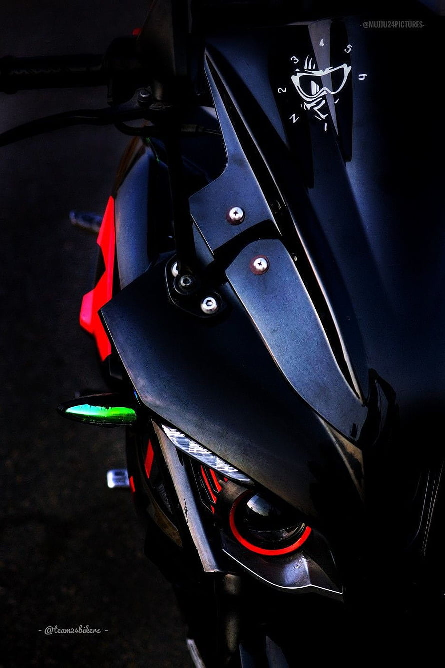 Close-up of a modified RS 200 motorcycle front fairing with red accents and dark matte finish HD phone wallpaper