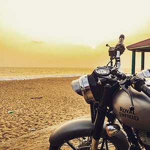 Royal Enfield Classic 350 Motorcycle Parked on a Sandy Beach at Golden Hour HD phone wallpaper
