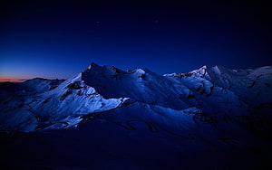 Snow-Capped Mountain Ranges Under a Deep Blue Twilight Sky HD wallpaper