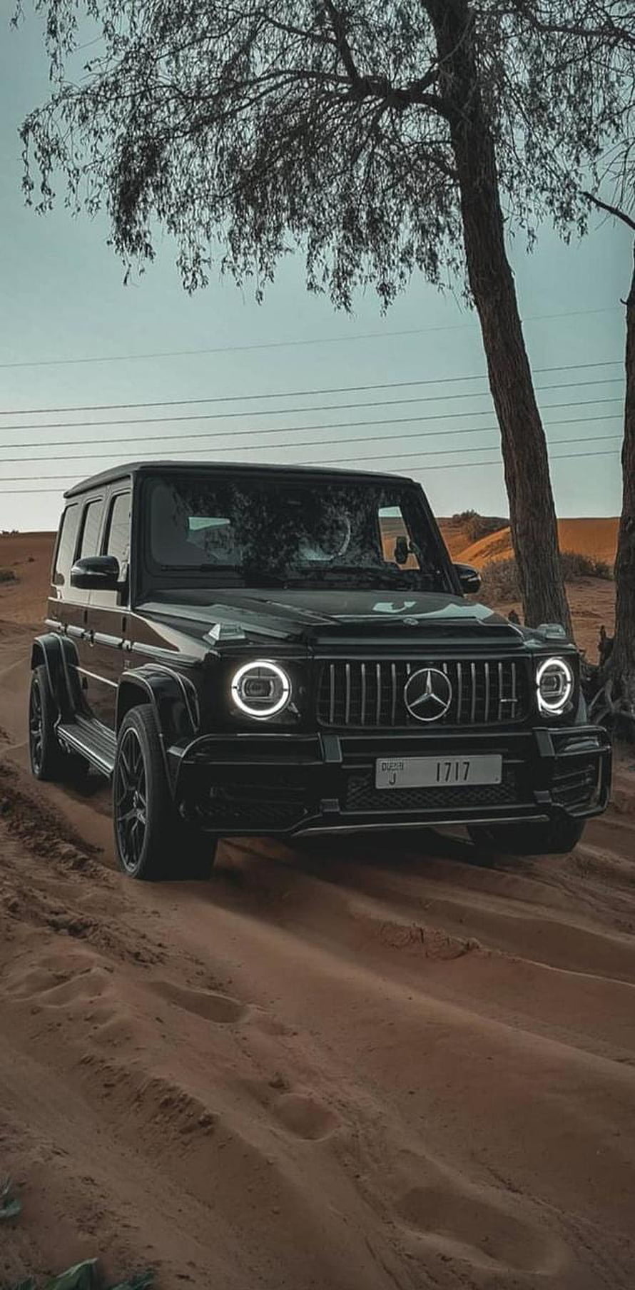 Black Mercedes-Benz G-Class SUV parked on a sandy desert trail under a tree HD phone wallpaper
