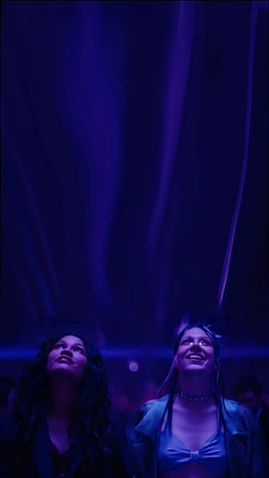 Jules from Euphoria in a moody purple-lit concert scene with a friend HD phone wallpaper