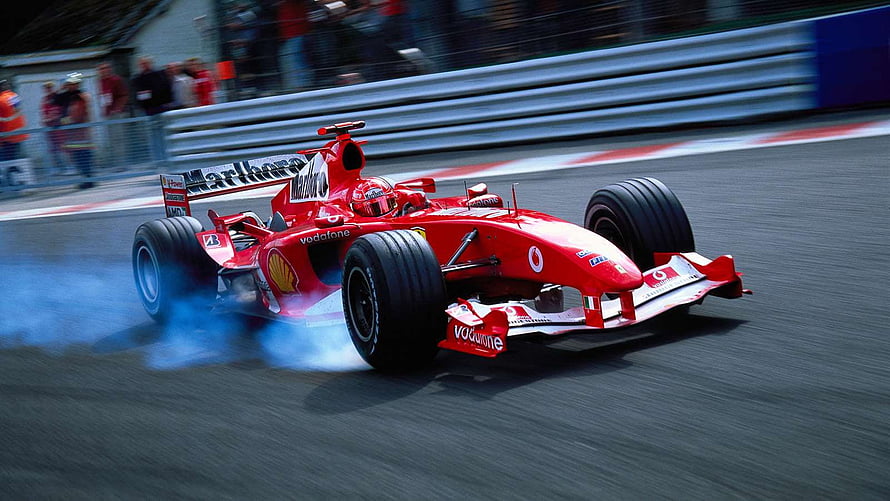 Ferrari F2004 Formula 1 race car drifting on the track with tire smoke HD wallpaper
