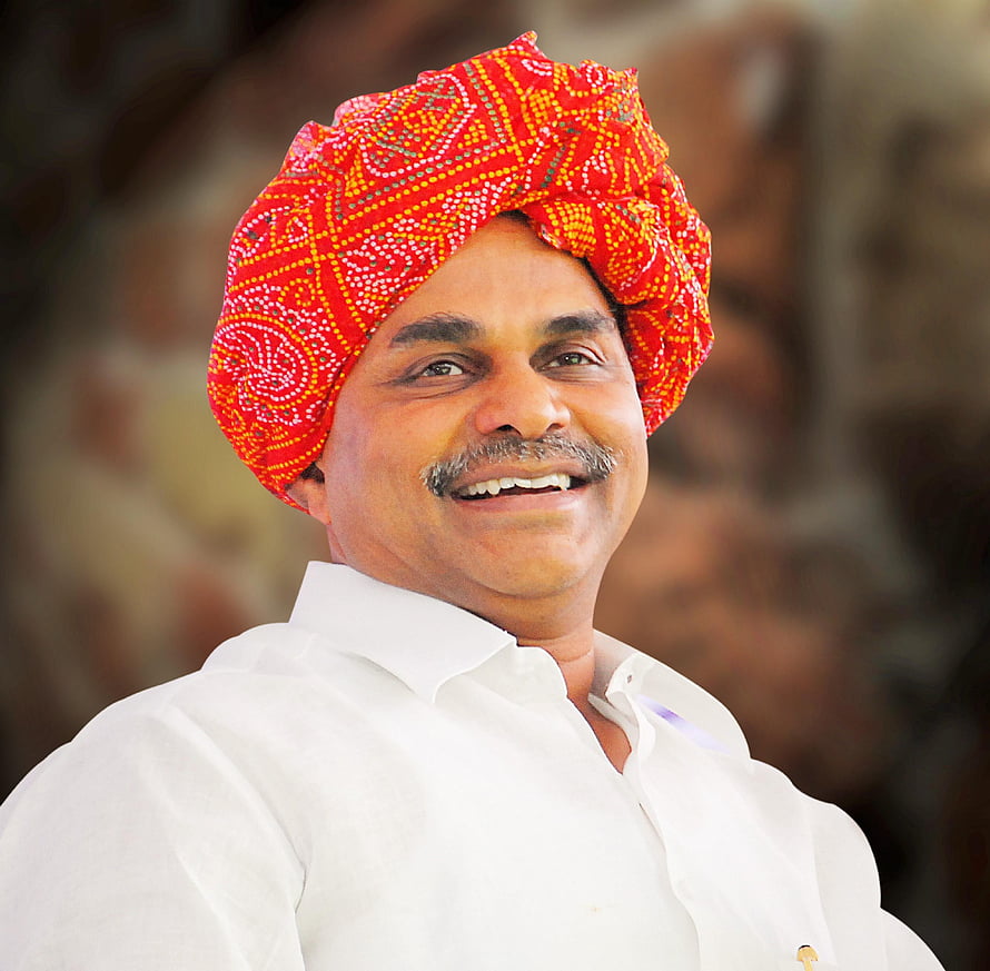 Portrait of a smiling man wearing a vibrant red patterned turban and white shirt HD wallpaper