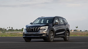 Mahindra XUV700 SUV on an open road with a sleek black exterior and modern front grille design HD wallpaper