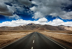 Leh Ladakh Highway Stretching Through Arid Plateau Landscape Under Dramatic Clouds HD wallpaper