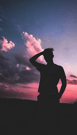 Silhouette of a man standing against a dramatic pink and purple sunset sky with clouds, Boy Shadow, sad pose boy HD phone wallpaper
