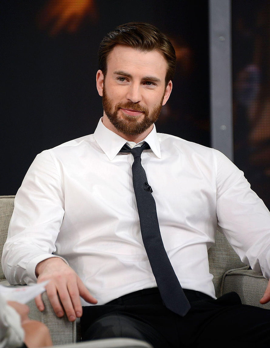 Chris Evans in a white dress shirt and dark tie seated during a panel interview HD phone wallpaper