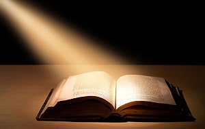 Open Bible Illuminated by Warm Light on a Wooden Surface HD wallpaper