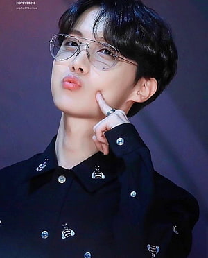 J-Hope from BTS in a black bee-embroidered shirt with clear glasses and a playful pose HD phone wallpaper