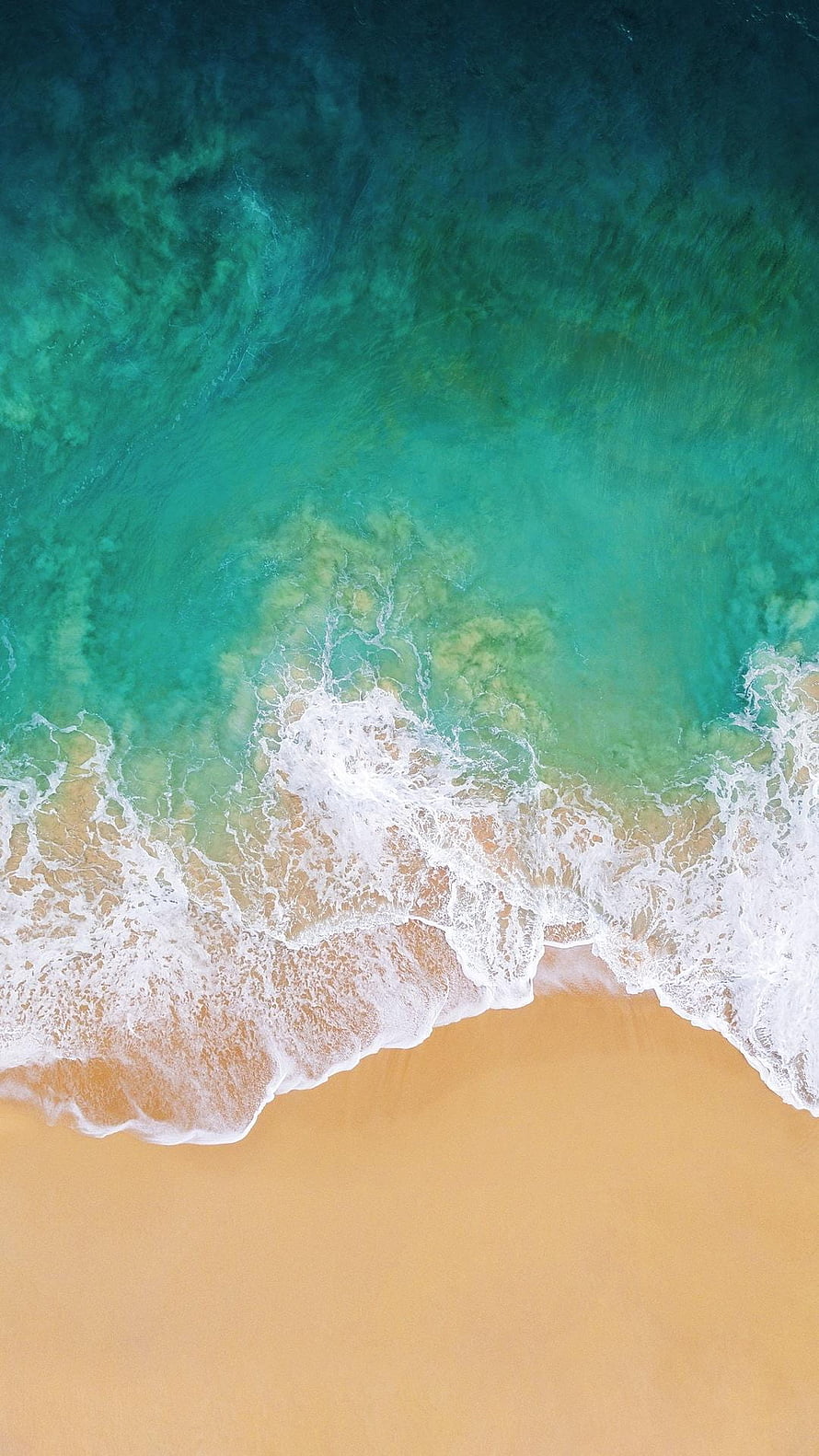 Aerial View of Turquoise Ocean Waves Lapping Against Golden Sandy Beach HD phone wallpaper