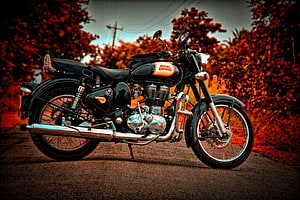 Classic Royal Enfield Motorcycle Parked on a Scenic Autumn Road HD wallpaper