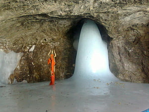 Amarnath Cave Temple Interior with Ice Shiva Lingam and Sacred Offering HD wallpaper