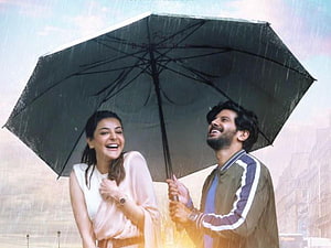 Kajal Aggarwal and Dulquer Salmaan share a joyful moment under a black umbrella in the rain HD wallpaper