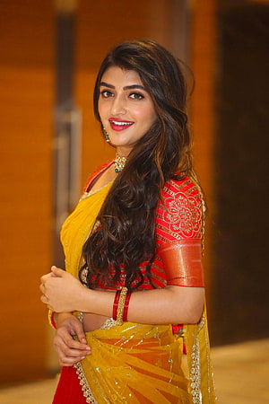 Sreeleela in a vibrant red and yellow half saree with gold embroidery and traditional jewelry HD phone wallpaper