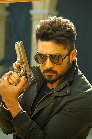 Surya in Anjaan holding a gold pistol with aviator sunglasses and black leather jacket HD phone wallpaper