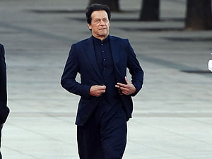 Imran Khan Walking in a Dark Suit on a Paved Plaza HD wallpaper