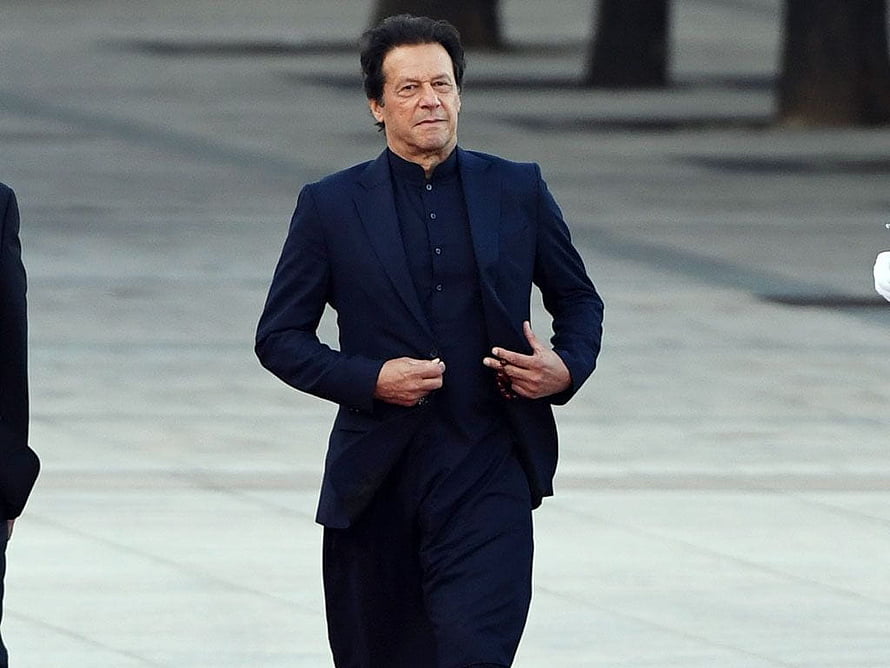 Imran Khan Walking in a Dark Suit on a Paved Plaza HD wallpaper