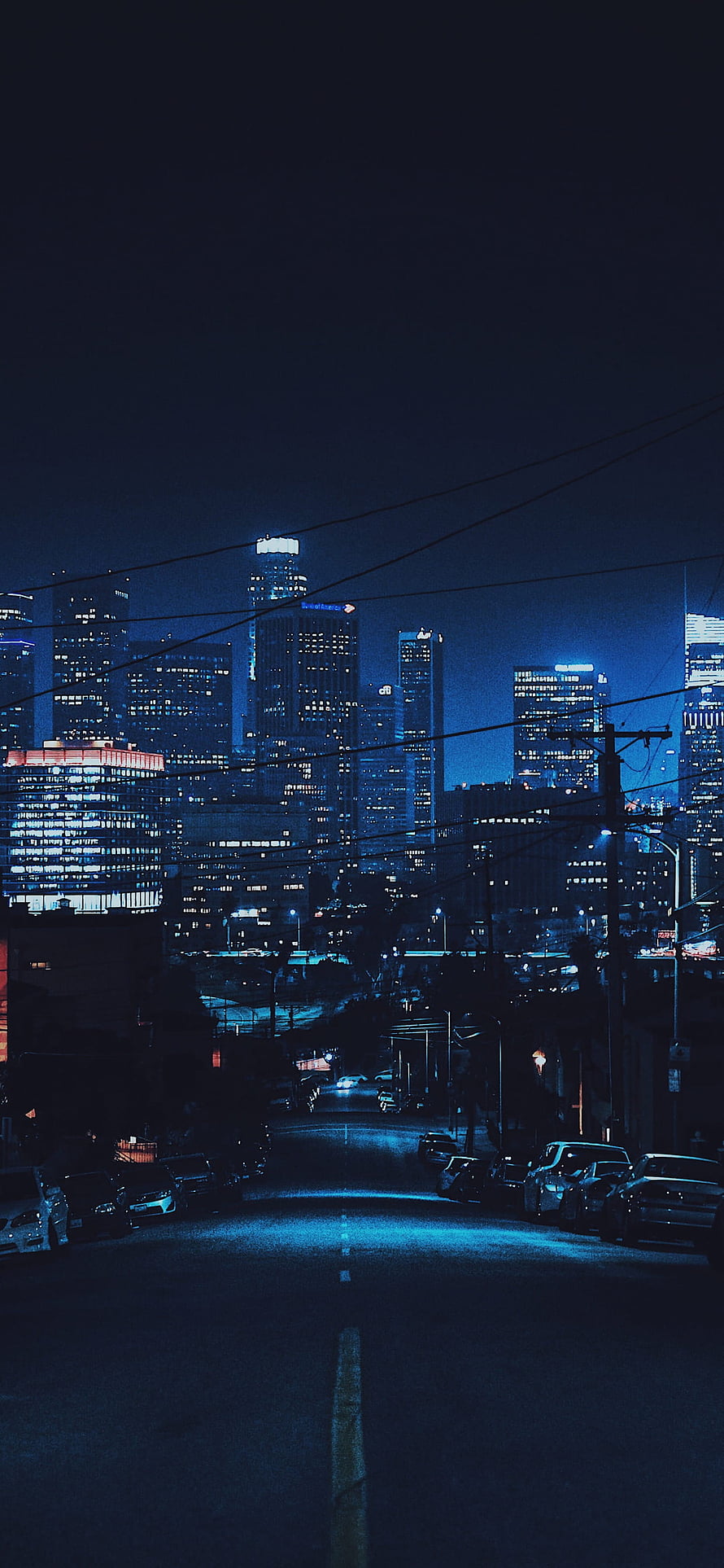Moody Nighttime Cityscape with Empty Street and Glowing Skyscrapers HD phone wallpaper