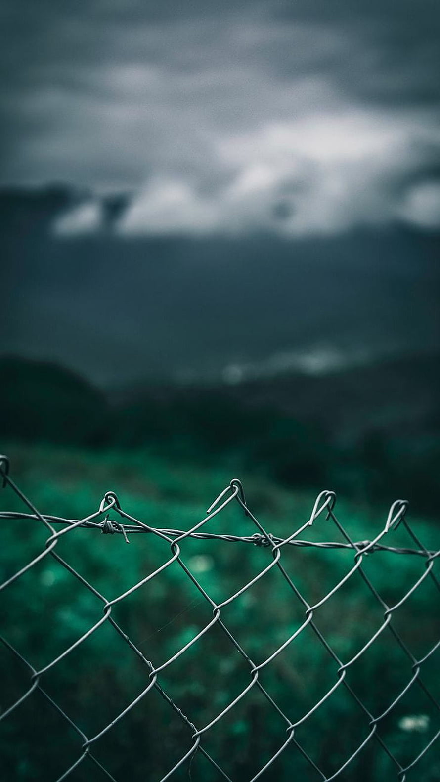 Moody Chain Link Fence Against Dark Stormy Mountain Landscape HD phone wallpaper