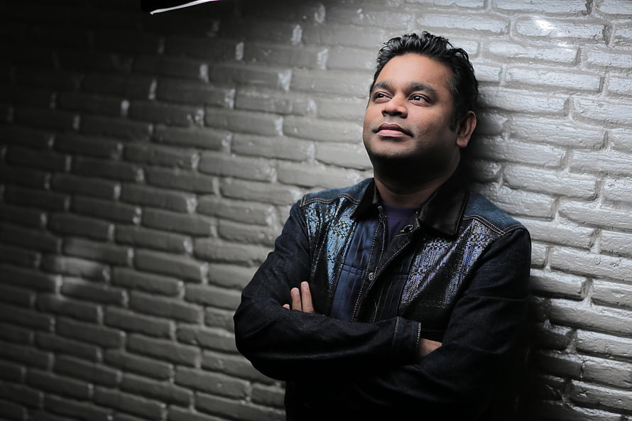 AR Rahman Portrait Against Textured Brick Wall in Dramatic Studio Lighting HD wallpaper