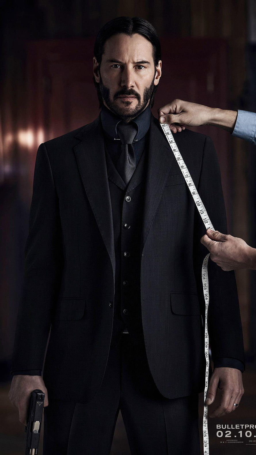 John Wick in a tailored black suit with a measuring tape and pistol HD phone wallpaper