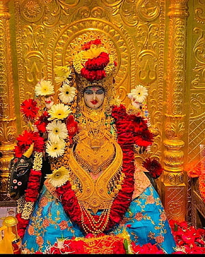 Meldi Maa Malataj Temple Idol Adorned in Gold Jewelry and Vibrant Flower Garlands HD phone wallpaper