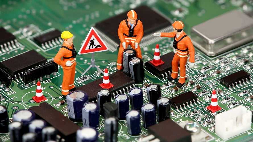Miniature construction workers repairing electronic components on a green circuit board HD wallpaper