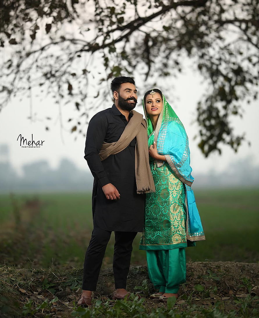 Punjabi couple in traditional ethnic wear posing in a misty green field HD phone wallpaper