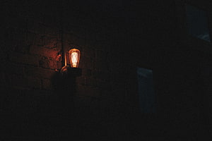Glowing Edison Bulb on Dark Brick Wall at Night HD wallpaper