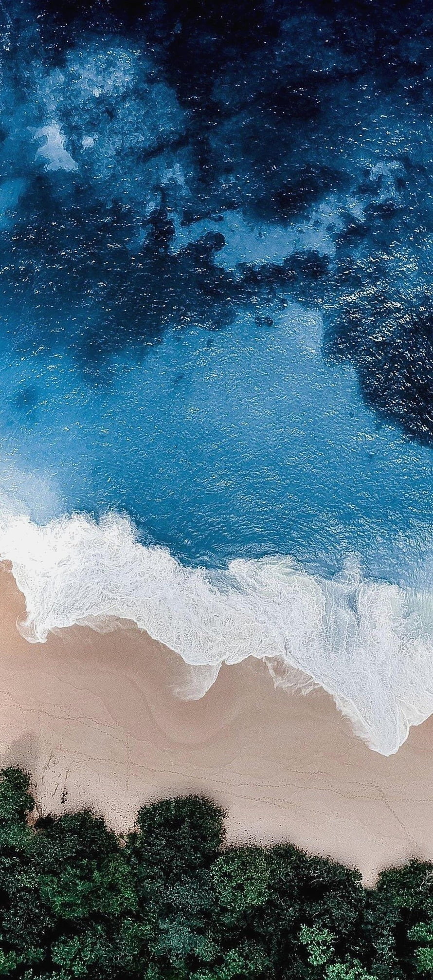Aerial View of Turquoise Ocean Waves Crashing on Sandy Shore with Lush Green Foliage HD phone wallpaper
