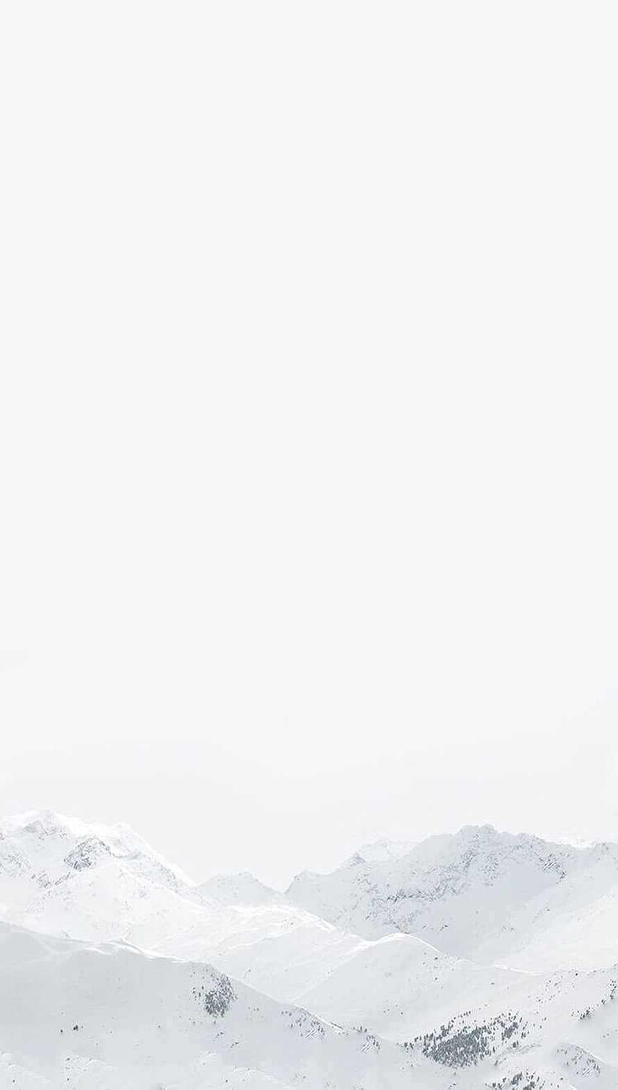 Serene Snow-Covered Mountain Range Under a Pale Winter Sky HD phone wallpaper