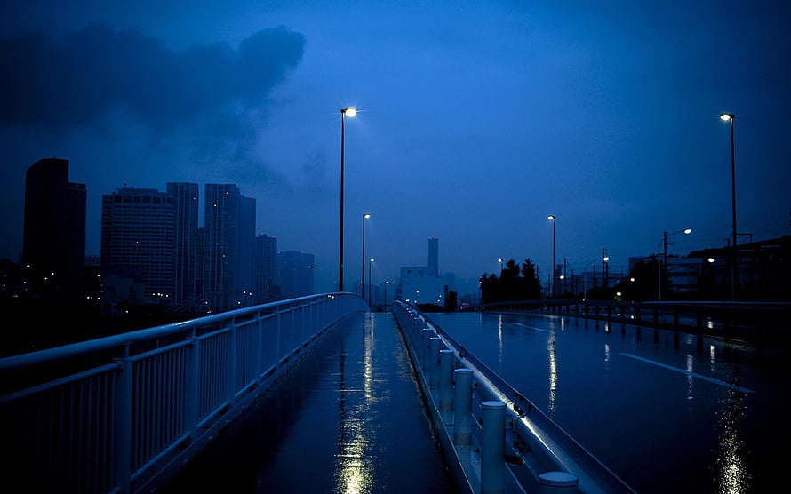 Moody Blue Cityscape at Dusk with Wet Bridge and Streetlights HD wallpaper