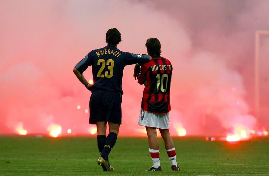 Marco Materazzi and Rui Costa on the pitch with red smoke in the background HD wallpaper
